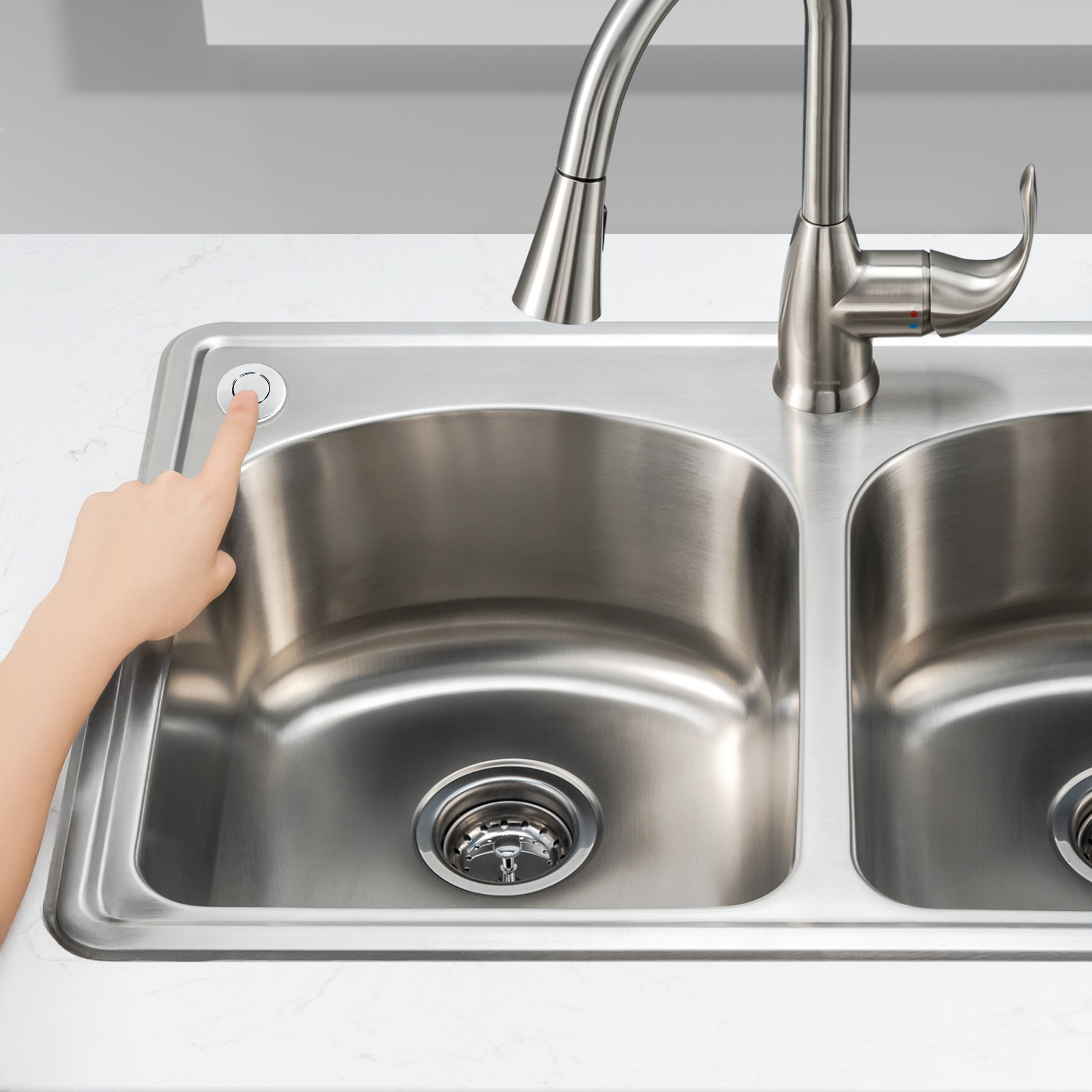 Man pressing disposal air switch installed on a kitchen sink top