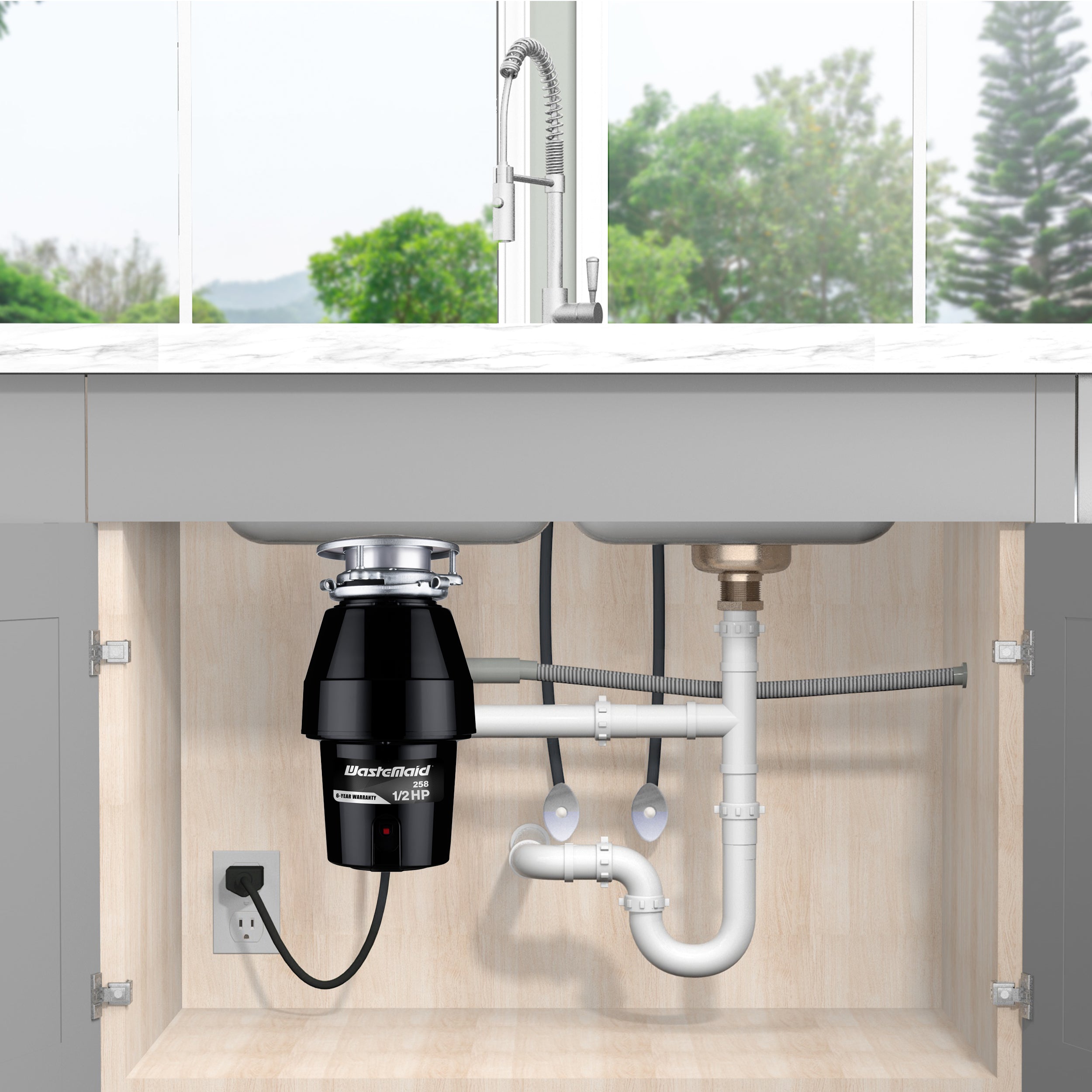 Garbage disposal unit under a kitchen sink with visible plumbing and electrical outlet.