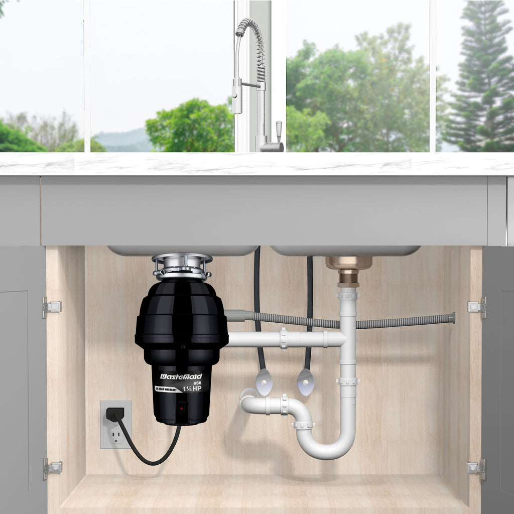 Garbage disposal unit under a kitchen sink with visible plumbing.