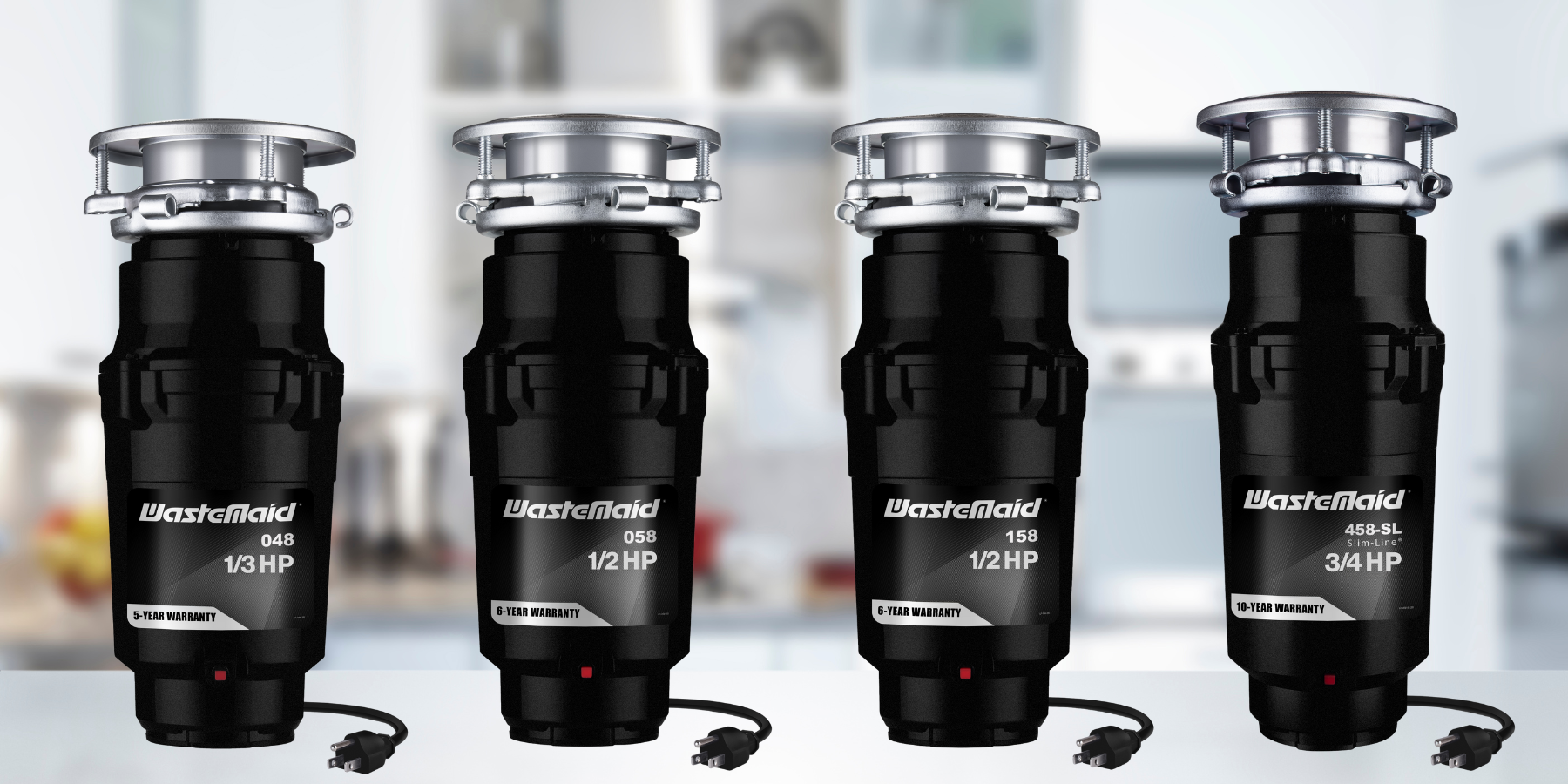 Four WasteMaid garbage disposals with different horsepower ratings on a blurred kitchen background.