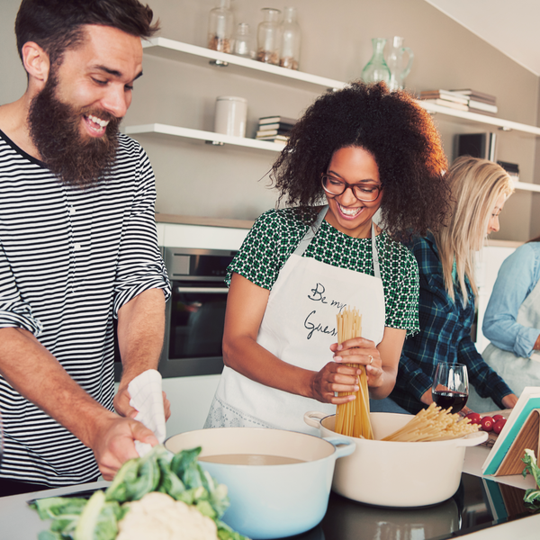 Two people cooking together in a kitchen with various ingredients.